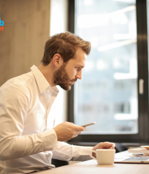 Parent using laptop at home with child nearby.