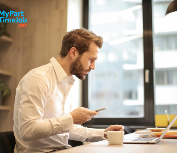 Parent using laptop at home with child nearby.